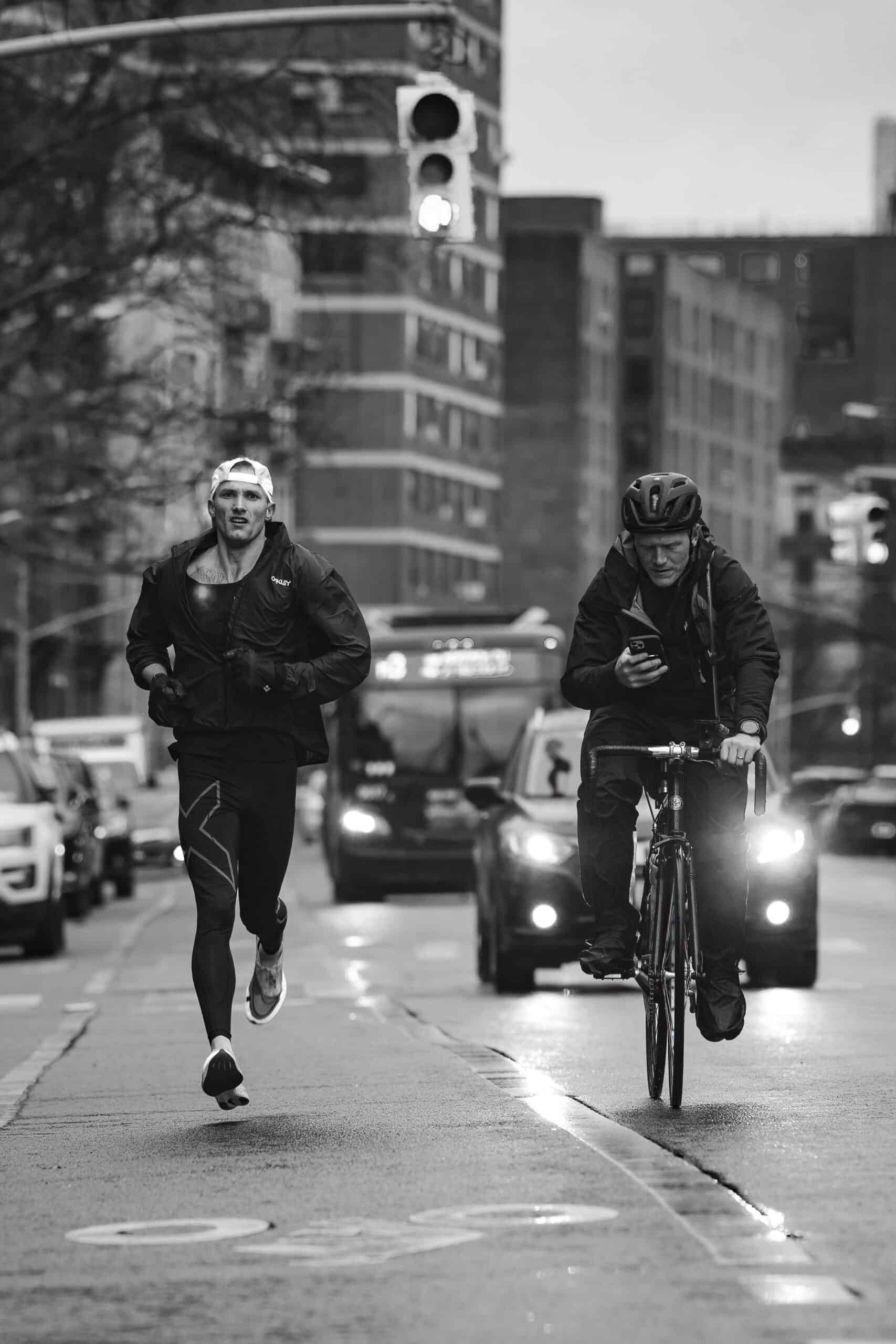 Blake running alongside a cyclist in the city