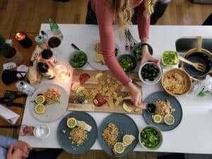 Overhead view of table with salad, salmon, charcuterie, and side dishes