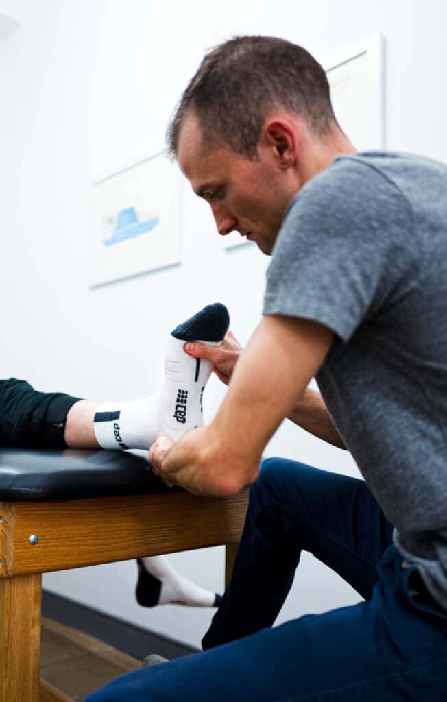 Physical therapist treating athlete's foot on a treatment table