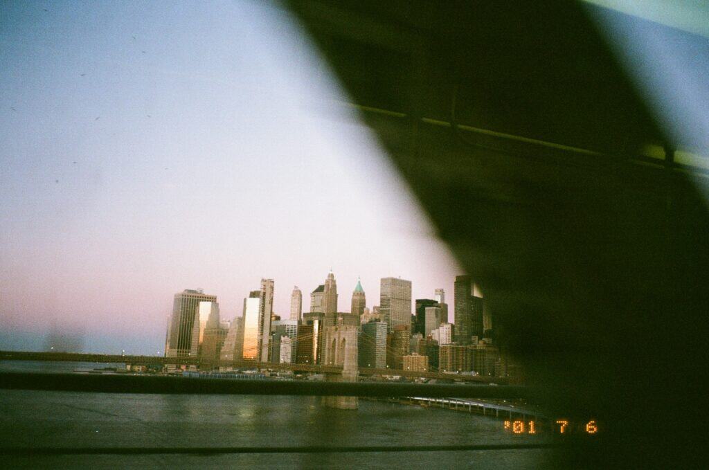 The Manhattan skyline at sunrise, viewed through the window of a moving train